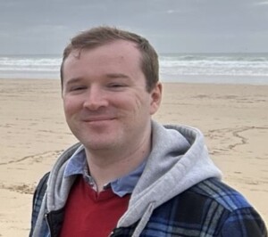 Photo of Daniel Loy standing on a beach.