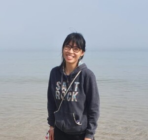 Photo of a woman standing in front of a large body of water.
