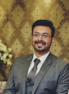 Photograph of a man sitting in a chair.