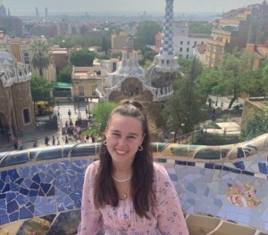 A photo of a woman sitting in front of a city backdrop.