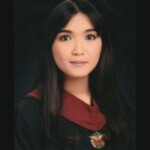 Photograph of the head and shoulders of a woman wearing a graduation gown.