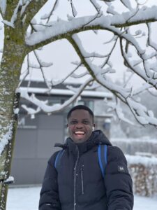 A photo of the head and shoulders of a man standing in front of a snowy backdrop.