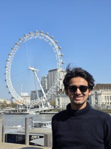 Photograph of the head and shoulders of a man with the River Thames and London Eye in the background.
