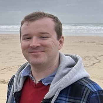 Photo of Daniel Loy standing on a beach.