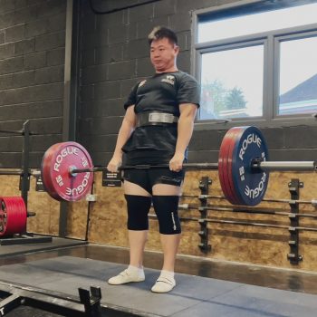 Photograph of a man engaged in weight lifting.
