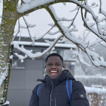 A photo of the head and shoulders of a man standing in front of a snowy backdrop.