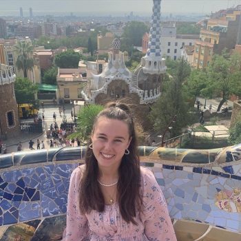 A photo of a woman sitting in front of a city backdrop.